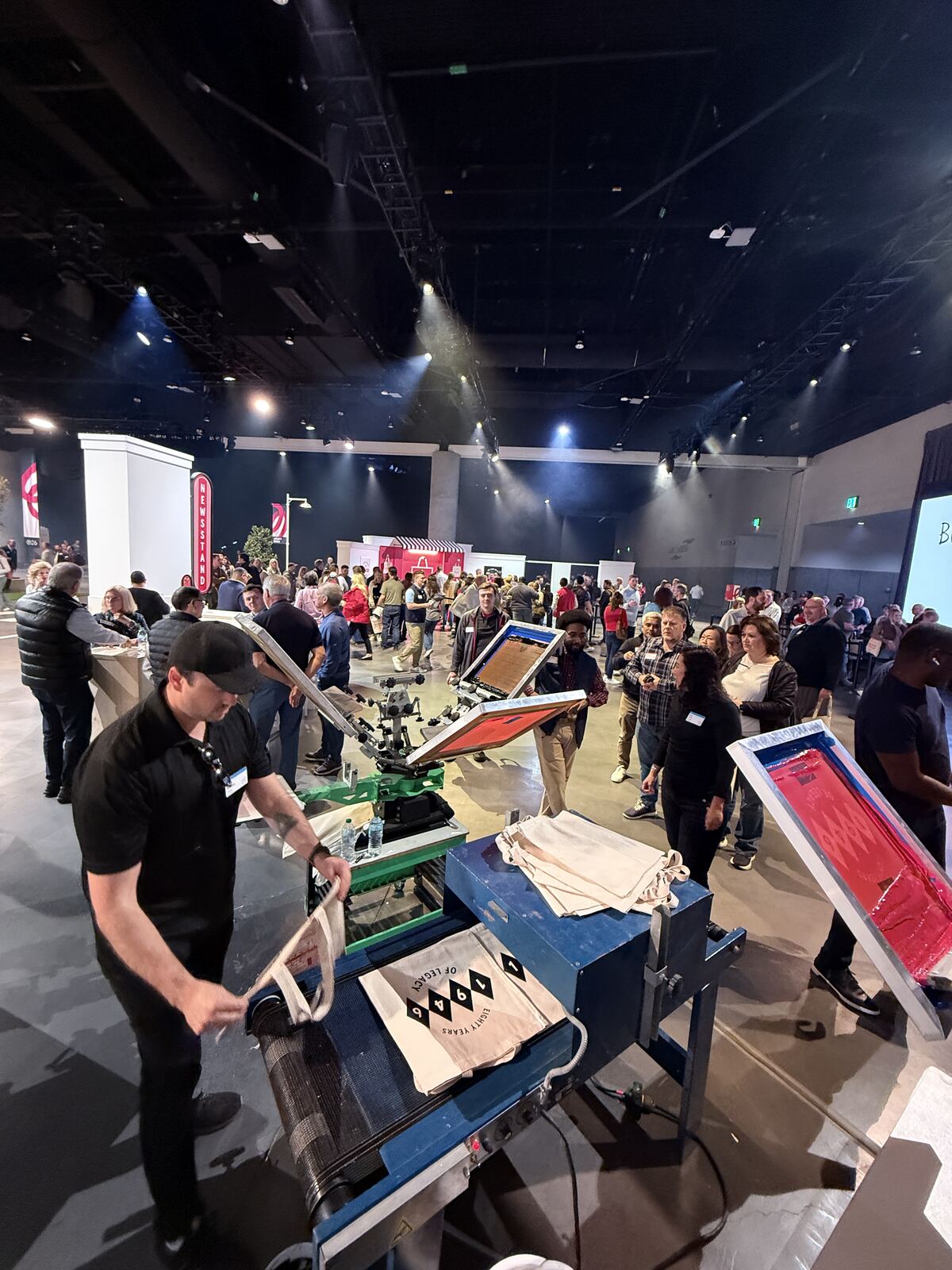 Detail shot of printing equipment and work surface with ink containers visible at a conference booth