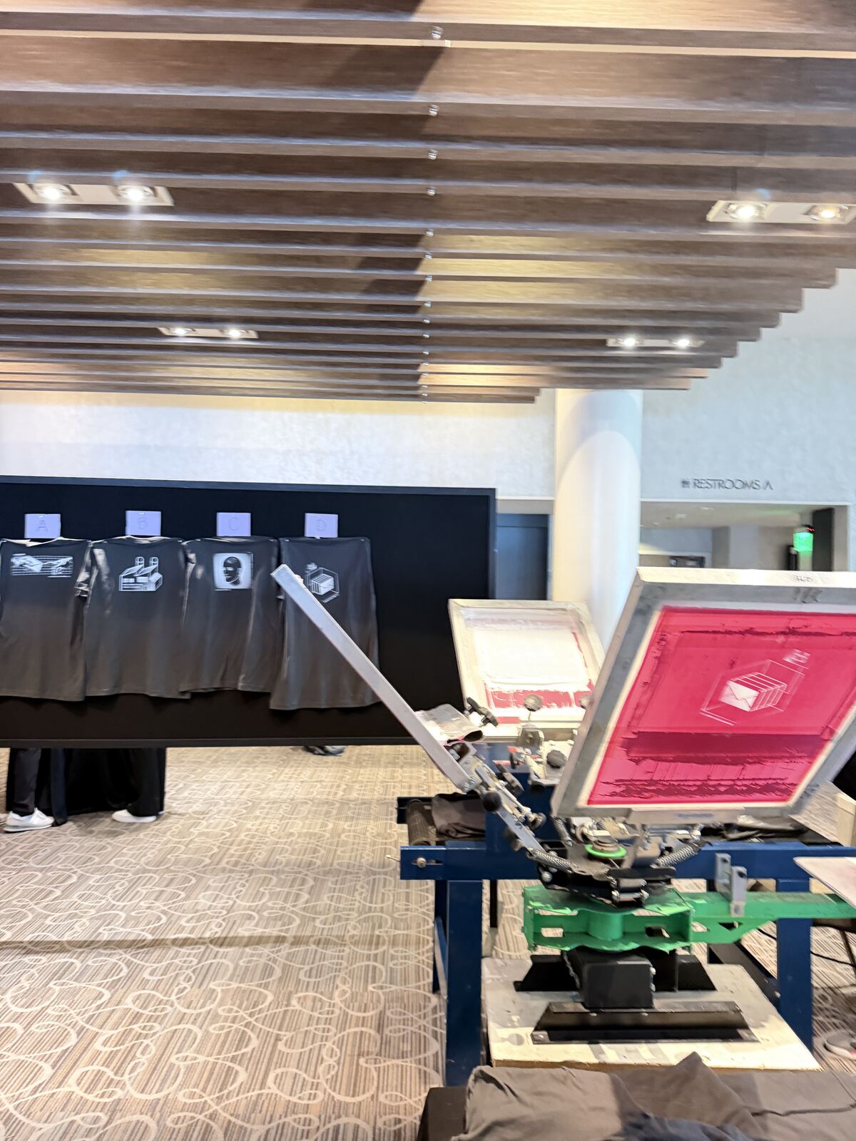 Interior shot of printing machinery and decorated apparel displays in a trade show setting